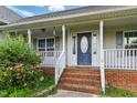 Charming front entrance with a covered porch, decorative door, and well-maintained landscaping at 71 Havistock Ct, Cameron, NC 28326