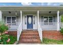 Close-up of the front porch showcasing brick steps, white railings, and a decorative front door at 71 Havistock Ct, Cameron, NC 28326