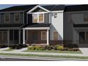 Charming townhome with brick accents, a covered porch, and a professionally landscaped yard with vibrant flowers at 713 Chandler Stone Dr, Zebulon, NC 27597