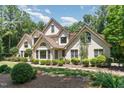 Charming two-story home with white brick and manicured landscaping, set amongst mature trees at 90021 Hoey, Chapel Hill, NC 27517