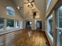 Spacious living room boasting hardwood floors, tall ceilings, large windows, and an open floor plan to the kitchen at 90021 Hoey, Chapel Hill, NC 27517