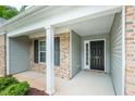 Inviting entryway featuring a covered porch with brick accents and a stylish black front door at 905 Alice Ct, Haw River, NC 27258