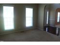 A carpeted room featuring a pair of large windows allowing natural light at 919 Middle Ground Ave, Rolesville, NC 27571