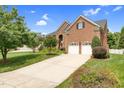 Beautiful brick home with a spacious driveway, lush lawn, and mature trees at 9639 Clubvalley Way, Raleigh, NC 27617