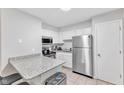 Well-lit kitchen features white cabinets, stainless appliances, and granite countertops at 101 Oyster Bay Ct # B2, Cary, NC 27513
