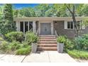 Inviting front entrance with brick steps, double doors, manicured landscaping, and stylish planters at 10909 Raven Rock Dr, Raleigh, NC 27614
