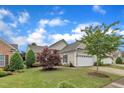 Beautiful single-story home with lush landscaping, a two-car garage, and a well-maintained lawn at 113 Dowington Ln, Cary, NC 27519