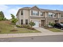 Inviting townhome featuring a one car garage, neutral siding, well-maintained landscaping, and a charming facade at 1136 Longitude Dr, Durham, NC 27713