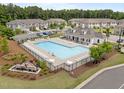 Community pool with lounge chairs, tables, white clubhouse, landscaping and surrounding townhomes at 1136 Longitude Dr, Durham, NC 27713