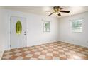 Open-concept living room with abundant natural light, tiled floors, and a front door and multiple windows at 1309 Jackson St, Burlington, NC 27217