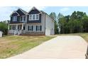 Two-story home boasts a long driveway, attached garage, and stylish gray siding at 1406 Reading Ct # 93 Kl, Burlington, NC 27217