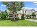 Two-story home featuring manicured lawn, stone accents, and a large tree in the front yard at 149 Cinder Cross Way, Garner, NC 27529