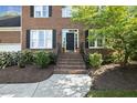 Brick home featuring a welcoming front entrance with beautiful landscaping and flower beds at 1601 Castalia Dr, Cary, NC 27513