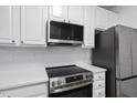 Modern kitchen features stainless steel appliances, white cabinets, and a stylish backsplash at 1723 Kudrow Ln, Morrisville, NC 27560