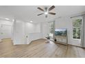 Bright living room featuring wood floors, a ceiling fan, and large windows offering natural light at 1723 Kudrow Ln, Morrisville, NC 27560