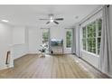 Bright living room featuring wood floors, a ceiling fan, and large windows offering natural light at 1723 Kudrow Ln, Morrisville, NC 27560