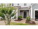Inviting front porch with well-maintained landscaping, brick accents, and stylish entry door at 19 Willow Green Dr, Clayton, NC 27527