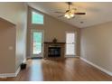 Cozy living room featuring hardwood floors, a brick fireplace, and vaulted ceilings offering ample natural light at 200 W Woodcroft Pkwy # 52A, Durham, NC 27713