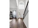 Grand foyer with high ceilings, a large window, hardwood floors, and an elegant staircase at 2003 Pilot Mountain Ct, Apex, NC 27502