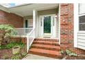 Inviting front porch with brick steps, white railings, and a charming entrance, offering a warm welcome at 2030 Prairie Ridge Ct, Fuquay Varina, NC 27526