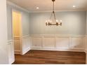 Dining room featuring wood floors, elegant lighting, and wainscoting at 2112 Coy St, Burlington, NC 27215