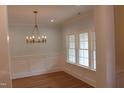 Dining room featuring wood floors, elegant lighting, and wainscoting at 2112 Coy St, Burlington, NC 27215
