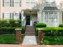 Inviting entrance with brick steps, iron railing and lush green shrubbery leading to a covered front porch at 2503 Saint Pauls Sq, Raleigh, NC 27614