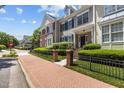 Street view of townhomes with manicured lawns, brick accents, sidewalks and mature trees at 2503 Saint Pauls Sq, Raleigh, NC 27614