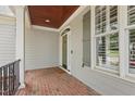 Covered front porch with brick flooring, offering a cozy and welcoming entrance at 2721 Cameron Pond Dr, Cary, NC 27519