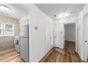 Well-lit kitchen features white appliances, tile counters, and laminate flooring at 2821 Edridge Ct, Raleigh, NC 27612