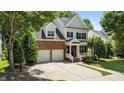 Charming two-story home featuring a brick facade, attached garage, and a well-manicured front lawn and a driveway at 303 Middleham Dr, Rolesville, NC 27571