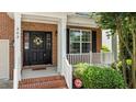 Close-up of the front door with a wreath and well manicured shrubs and landscaped porch at 303 Middleham Dr, Rolesville, NC 27571