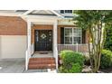 Close-up of the front door with a wreath and well manicured shrubs and landscaped porch at 303 Middleham Dr, Rolesville, NC 27571