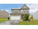 Charming two-story home featuring a two-car garage, a cozy front porch, and landscaped front yard at 307 W Copenhaver Dr, Clayton, NC 27527