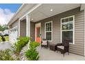 Cozy front porch with seating area and a colorful door; a great spot for relaxing and enjoying the neighborhood at 307 W Copenhaver Dr, Clayton, NC 27527