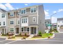 A stylish townhome features neutral siding, stone accents, landscaped greenery, and a well-maintained lawn at 3101 Brellon Ln, Durham, NC 27703