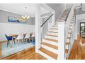 Elegant dining room with hardwood floors, stylish decor, and access to staircase at 320 Chickasaw Plum Dr, Holly Springs, NC 27540