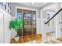 Inviting foyer featuring hardwood floors, a stylish front door, and staircase leading to the upper level at 320 Chickasaw Plum Dr, Holly Springs, NC 27540