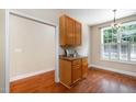 Dining area showcasing hardwood floors, a stylish light fixture, and ample cabinet space, creating a cozy space to enjoy meals at 33 Grapevine Trl, Durham, NC 27707