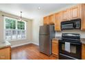 Functional kitchen featuring wood cabinets, stainless steel appliances, and a window for natural light, blending style and convenience at 33 Grapevine Trl, Durham, NC 27707