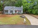 Well-maintained single-story home with a long driveway, manicured lawn, and mature trees at 3608 Meadow Creek Ln, Raleigh, NC 27616
