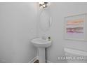 Bathroom featuring a pedestal sink, modern lighting, and framed art at 428 Longleaf Glen Lane, Zebulon, NC 27597