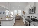 Bright kitchen featuring stainless steel appliances and an adjacent dining area at 428 Longleaf Glen Lane, Zebulon, NC 27597