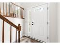 Entryway with white front door, hardwood floors, white trim, and wood banister at 5001 Simpson Dr, Sanford, NC 27330