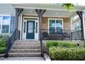 Inviting front porch with stone detail, stylish seating, and covered entryway at 5016 Trembath Ln, Cary, NC 27519