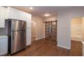 Open kitchen view with stainless steel refrigerator and barn door access to the bathroom at 6 First St, Franklinton, NC 27525