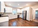 Updated kitchen with white cabinets, stainless steel appliances, and dark hardwood floors at 6 First St, Franklinton, NC 27525