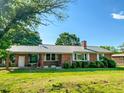 Well-maintained brick home with a metal roof, manicured lawn and established landscaping at 623 Chambers Rd, Rougemont, NC 27572