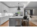 Modern kitchen with a wine fridge, stainless appliances, and large center island with bar seating at 6648 Mafolie Ct, Raleigh, NC 27613