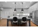 Elegant kitchen featuring a large island, stainless steel appliances, and stylish pendant lighting at 6648 Mafolie Ct, Raleigh, NC 27613